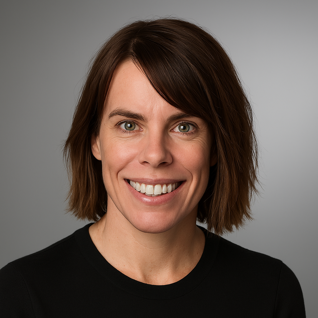 67f836aa8b60a_updated head shot (1) A woman with brown hair and wearing black is smiling.